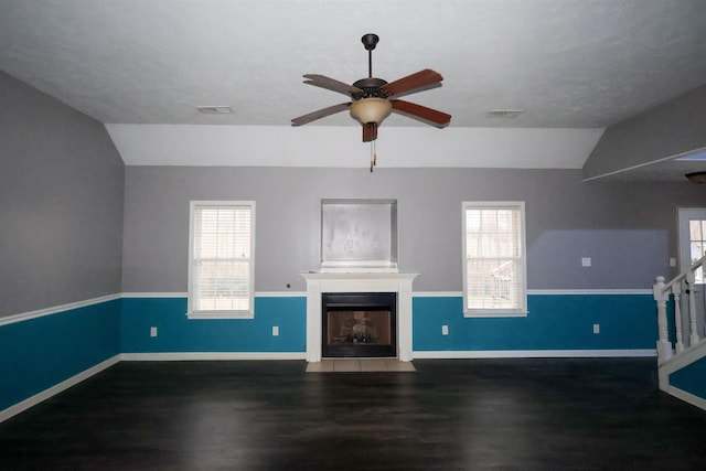 unfurnished living room with a healthy amount of sunlight, dark hardwood / wood-style floors, and vaulted ceiling