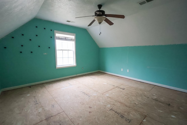 bonus room featuring ceiling fan, vaulted ceiling, and a textured ceiling