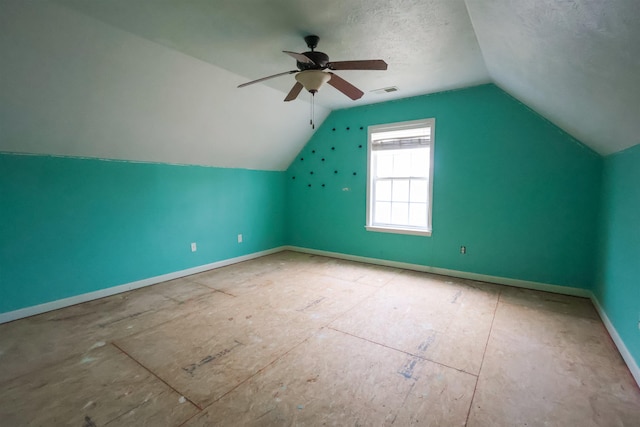 additional living space featuring ceiling fan, lofted ceiling, and a textured ceiling