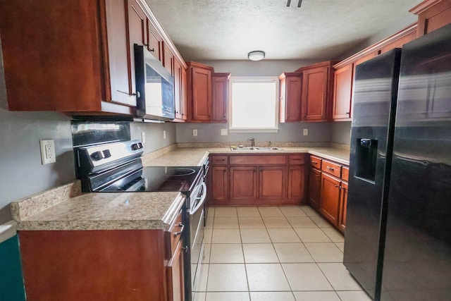 kitchen featuring sink, stainless steel appliances, a textured ceiling, and light tile patterned flooring