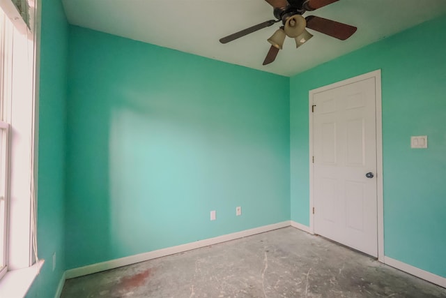 empty room with concrete flooring and ceiling fan