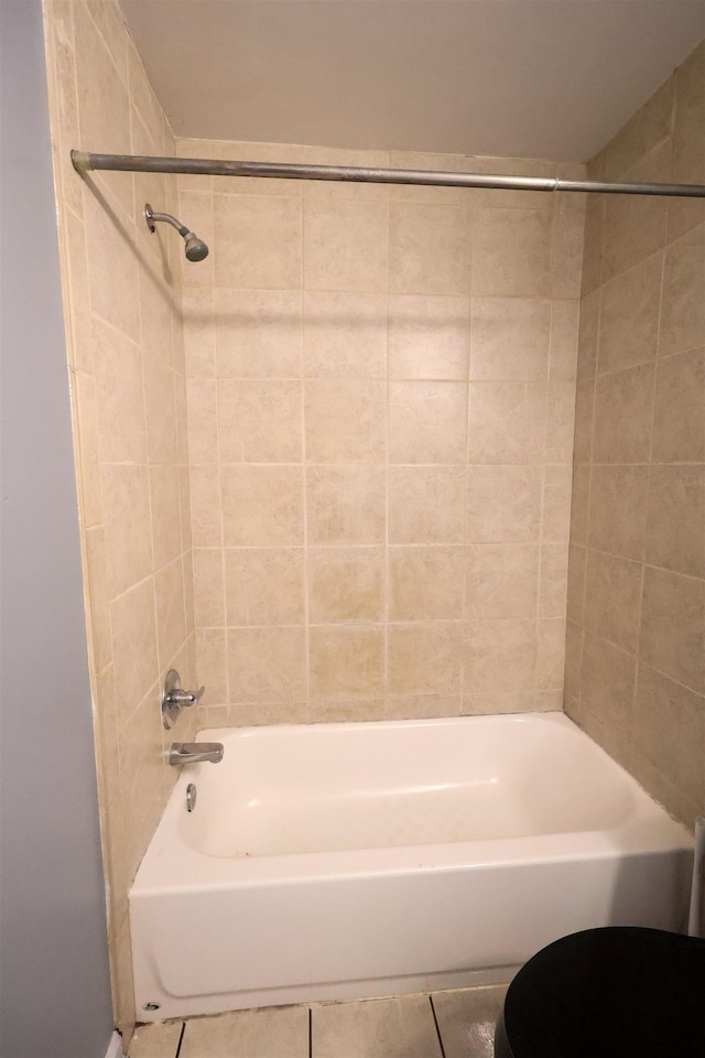 bathroom featuring tile patterned floors, toilet, and tiled shower / bath combo