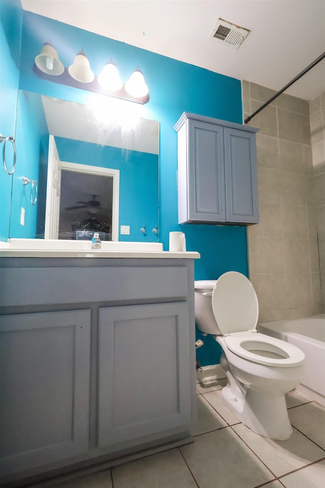 full bathroom featuring tiled shower / bath combo, vanity, tile patterned flooring, and toilet