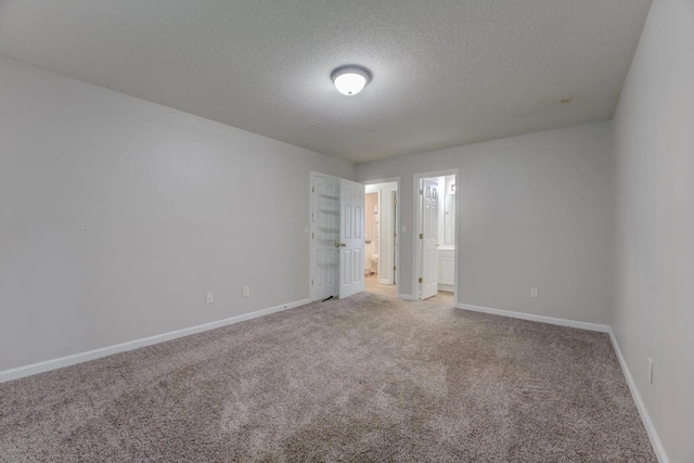 unfurnished room with carpet and a textured ceiling