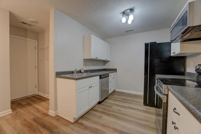 kitchen featuring sink, light hardwood / wood-style floors, a textured ceiling, white cabinets, and appliances with stainless steel finishes