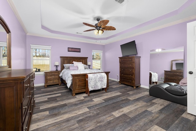 bedroom with crown molding, ceiling fan, a tray ceiling, and dark hardwood / wood-style flooring