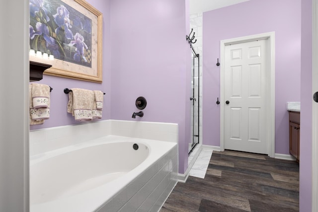 bathroom featuring vanity, wood-type flooring, and plus walk in shower