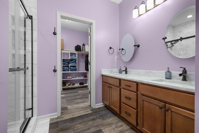 bathroom featuring vanity, a shower with shower door, and wood-type flooring