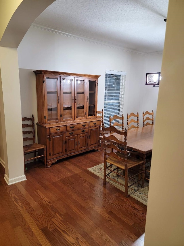 dining area featuring crown molding, dark hardwood / wood-style floors, and a textured ceiling