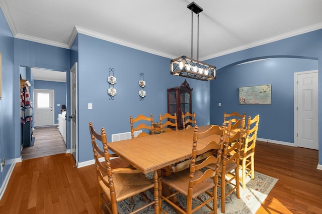 dining area with crown molding and dark hardwood / wood-style floors