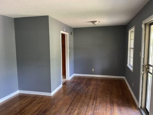 unfurnished room with dark wood-type flooring