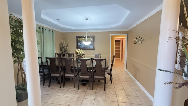 dining area with light tile patterned floors, a raised ceiling, and ornamental molding