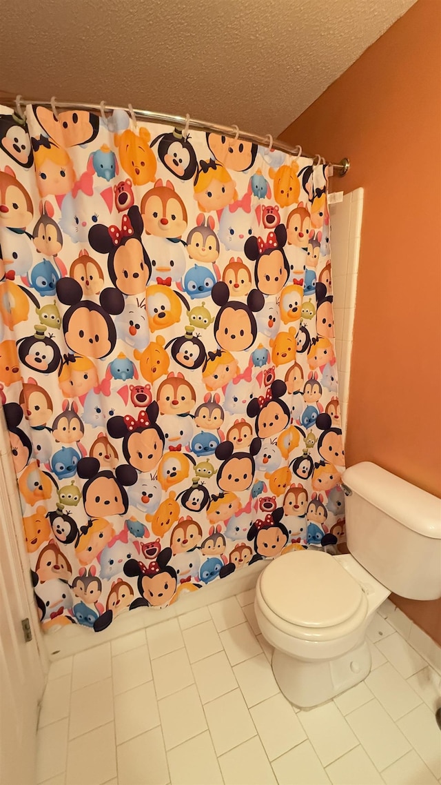 bathroom featuring tile patterned flooring, a textured ceiling, and toilet