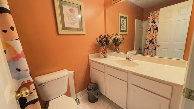 bathroom featuring tile patterned flooring, vanity, toilet, and walk in shower