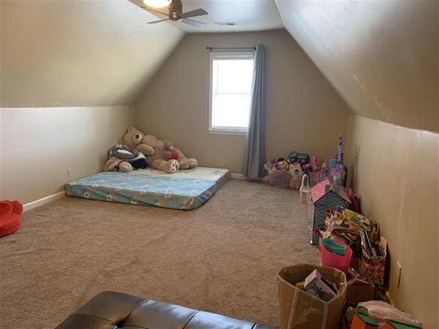 carpeted bedroom with ceiling fan and vaulted ceiling