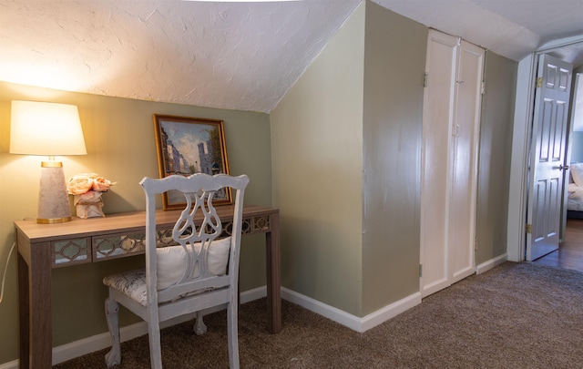 carpeted home office featuring lofted ceiling