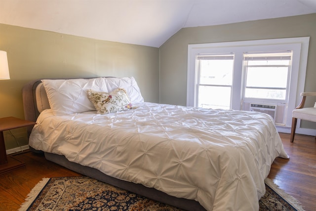 bedroom with dark hardwood / wood-style floors, cooling unit, and vaulted ceiling