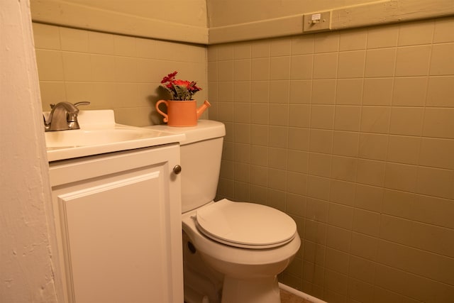 bathroom featuring vanity, tile walls, and toilet