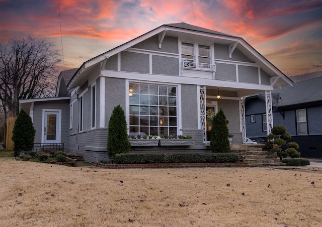 view of front facade with a balcony and a lawn