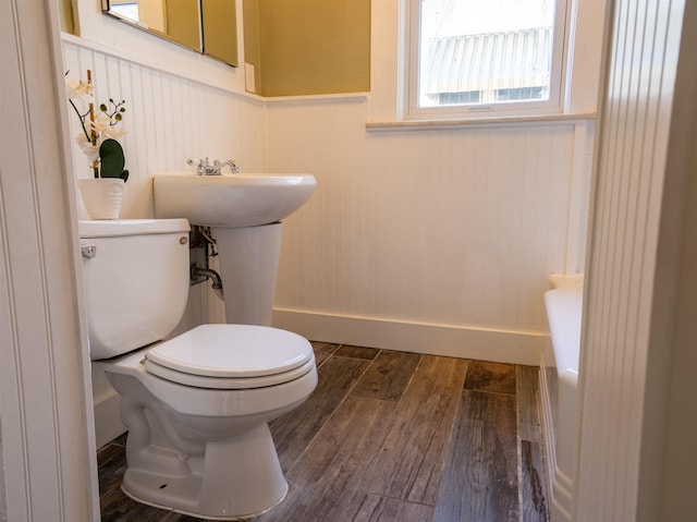 bathroom with toilet, wood-type flooring, and sink