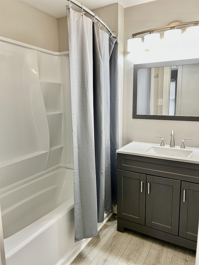 bathroom featuring vanity, hardwood / wood-style flooring, and shower / bath combo with shower curtain