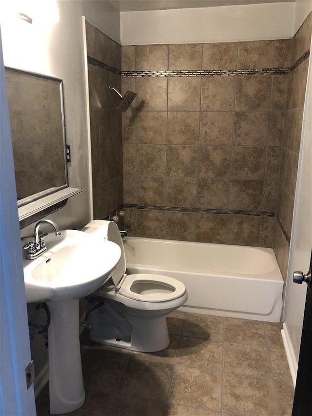 bathroom featuring tiled shower / bath combo and toilet