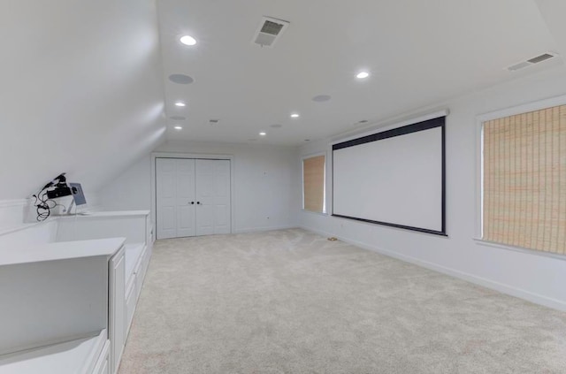 carpeted home theater featuring vaulted ceiling