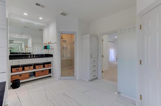 bathroom with crown molding, vanity, and an enclosed shower