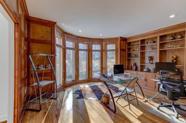 office space featuring built in shelves and light wood-type flooring