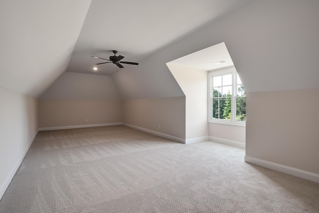 additional living space featuring vaulted ceiling, ceiling fan, and light colored carpet