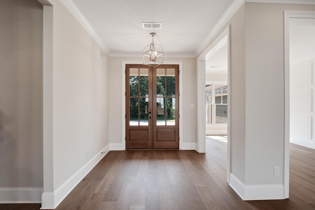 foyer with french doors, crown molding, and dark wood-type flooring