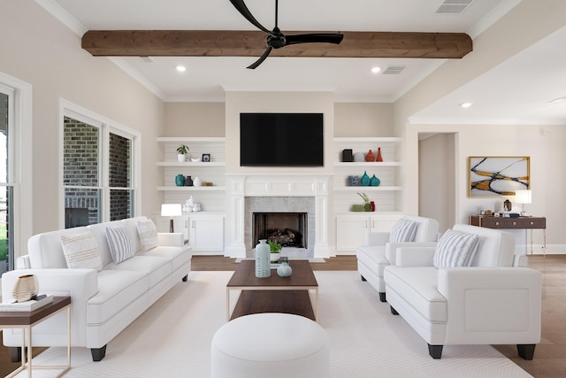 living room featuring built in features, ceiling fan, a premium fireplace, beam ceiling, and light hardwood / wood-style flooring