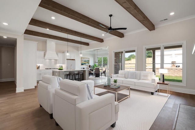 living room with hardwood / wood-style flooring, sink, ceiling fan, and beam ceiling