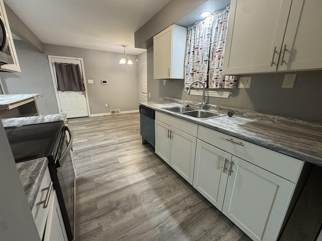 kitchen featuring white cabinetry, dishwasher, sink, hanging light fixtures, and black electric range oven