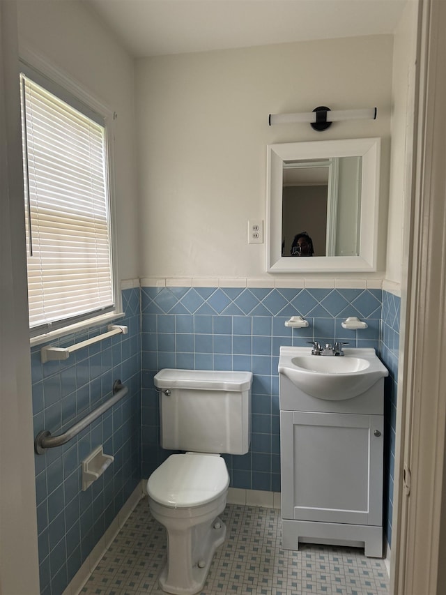 bathroom featuring toilet, tile patterned flooring, tile walls, and vanity