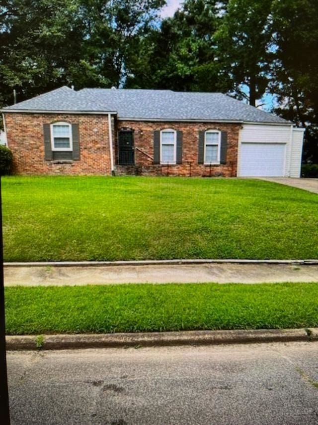 single story home featuring a garage and a front lawn