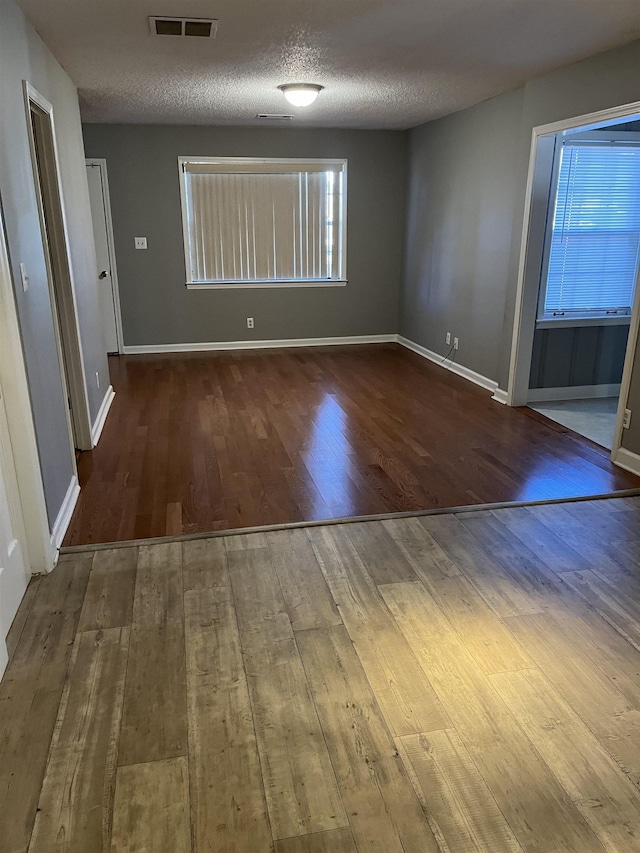 empty room with a textured ceiling and hardwood / wood-style floors