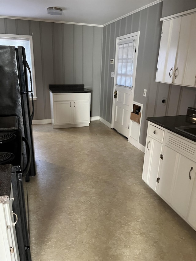 kitchen featuring black refrigerator and white cabinetry