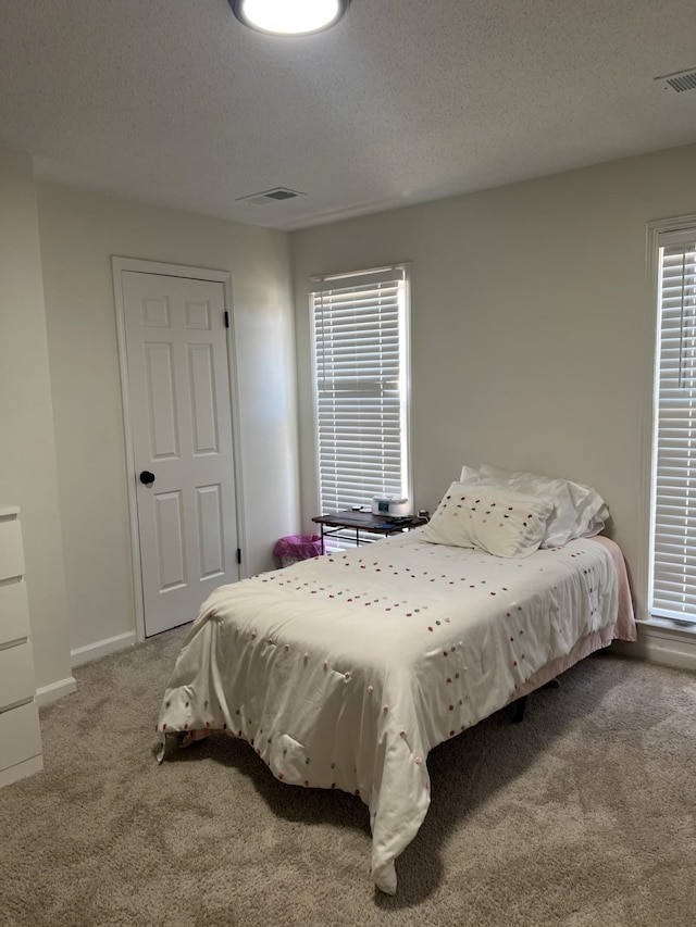 bedroom featuring a textured ceiling and carpet flooring