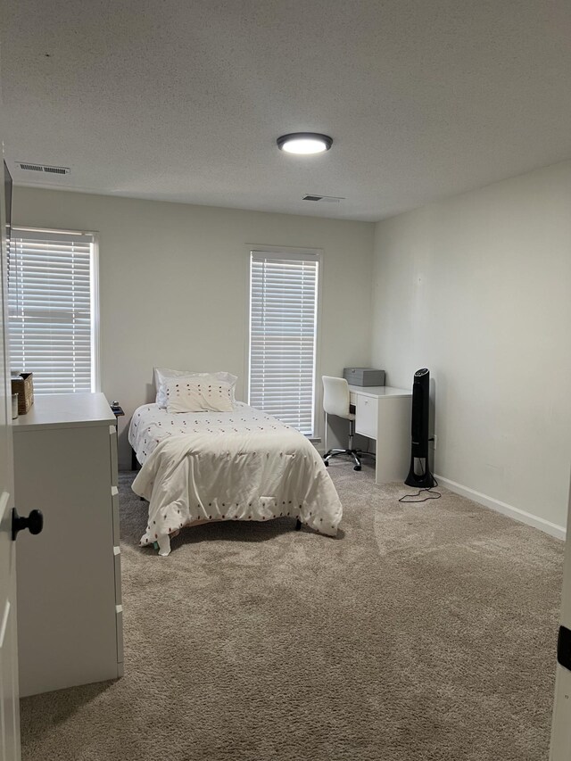 carpeted bedroom featuring a textured ceiling