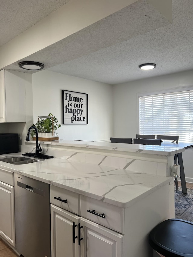 kitchen with sink, a textured ceiling, white cabinets, and dishwasher