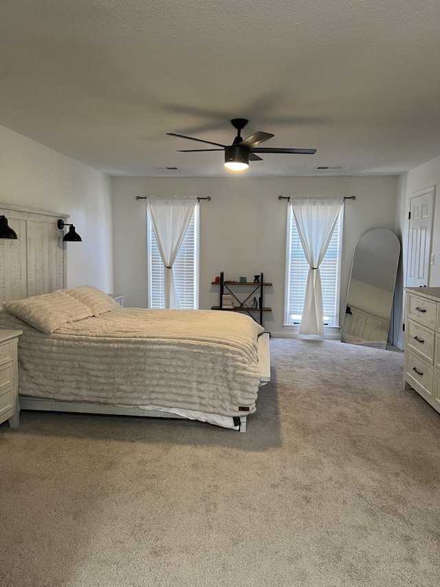 carpeted bedroom with ceiling fan and multiple windows