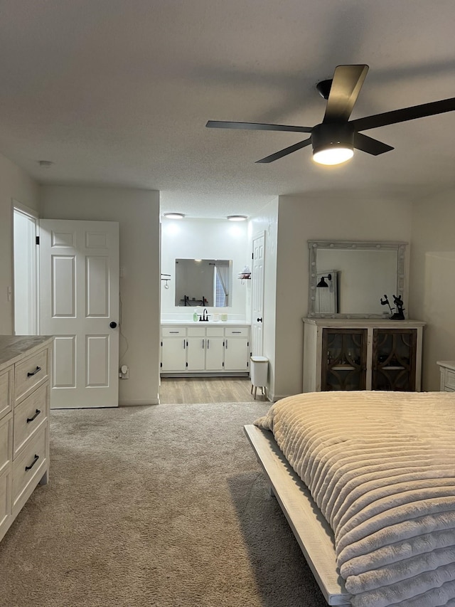 bedroom featuring ceiling fan, sink, and a textured ceiling