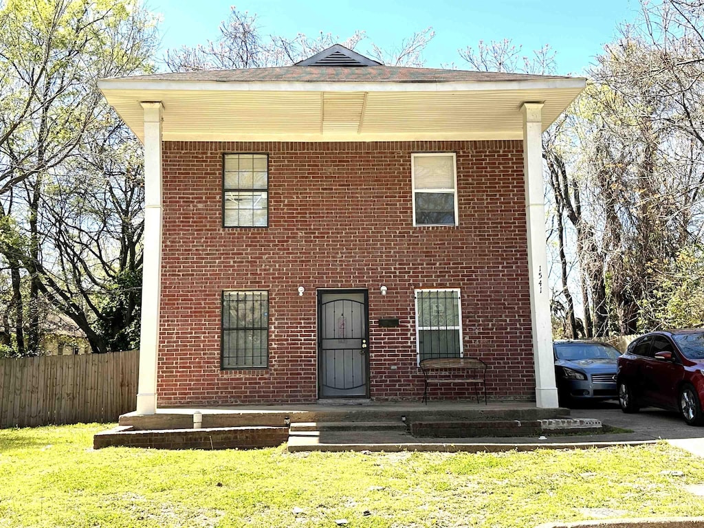 view of front of property featuring covered porch and a front yard