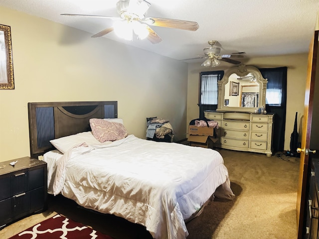 carpeted bedroom featuring ceiling fan and a textured ceiling