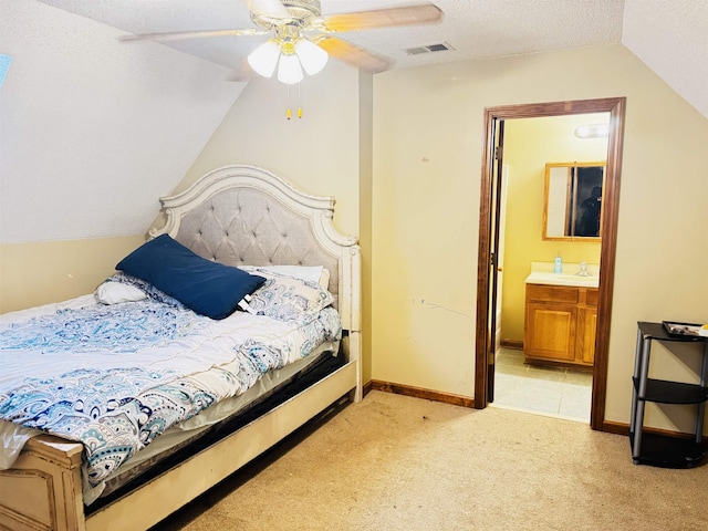 carpeted bedroom featuring a textured ceiling, ceiling fan, sink, connected bathroom, and lofted ceiling