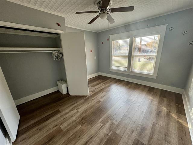 unfurnished bedroom with ceiling fan, dark hardwood / wood-style floors, and a closet