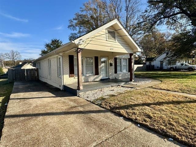 bungalow-style home featuring a front yard and covered porch