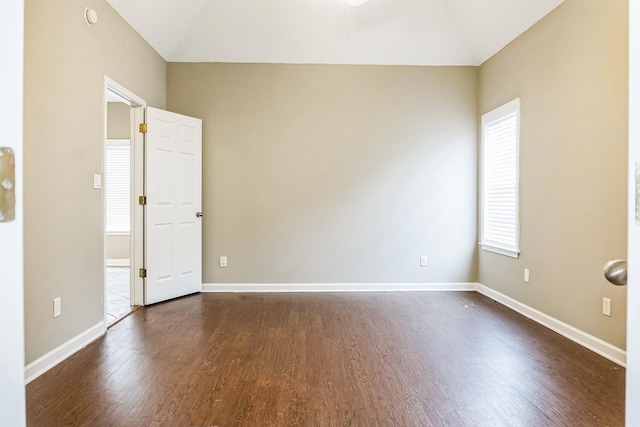 unfurnished room featuring dark wood-type flooring and a healthy amount of sunlight