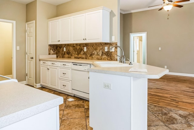 kitchen with white cabinetry, dishwasher, sink, tasteful backsplash, and kitchen peninsula